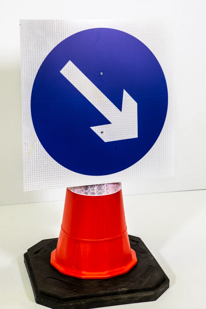 Reflective road sign mounted on a traffic cone